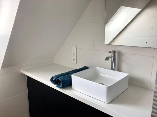 een badkamer met een witte wastafel en een blauwe handdoek bij TY BERNIC maison en Pierre, lumineuse, 2 à 4 pers à Riec Sur Belon in Riec-sur-Bélon