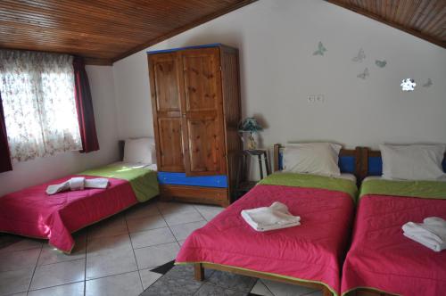 a bedroom with two beds and a wooden cabinet at Studios Ifigenia in Skala Potamias