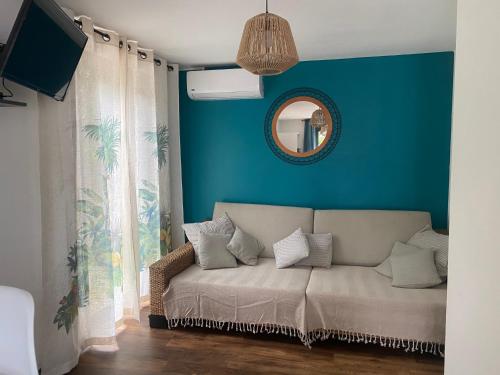 un sofá en una habitación con una pared azul en Le Palan en Saint-Pierre