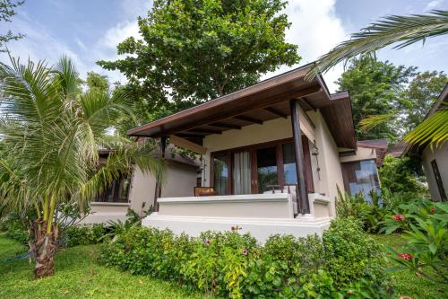 a small house with a garden and trees at Samed Tamarind Beach Resort in Ko Samed