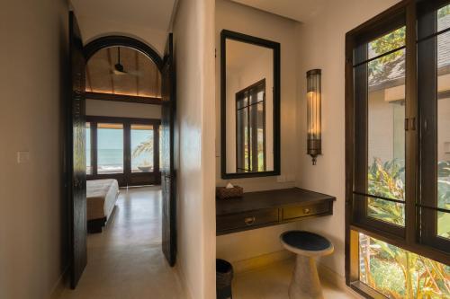 einen Flur mit einem Spiegel und einem Hocker in einem Zimmer in der Unterkunft Samed Tamarind Beach Resort in Ko Samed