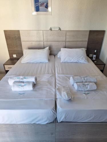 a bed with two towels and two pillows on it at Tassos 2 in Pefkohori