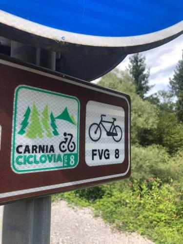 a sign on the side of a road with a bike at Holiday Guesthouse La Casina di Butzi pet friendly - Terme di Arta - Zoncolan in Arta Terme
