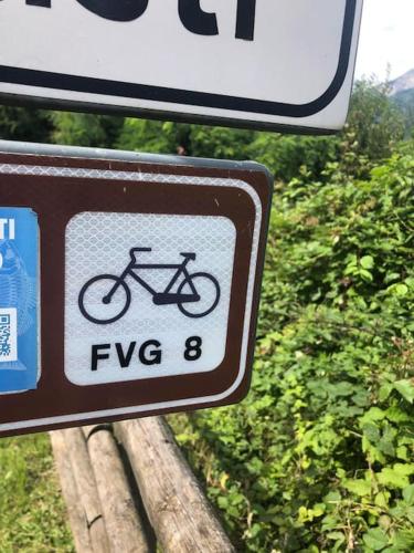 a sign with a bike on the side of a road at Holiday Guesthouse La Casina di Butzi pet friendly - Terme di Arta - Zoncolan in Arta Terme