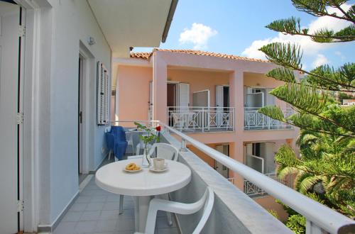 a balcony with a white table and a building at Dolphin Hotel in Skopelos Town