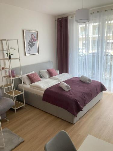 sypialnia z dużym łóżkiem i fioletowym kocem w obiekcie Apartament studio Perła 3 w mieście Lublin