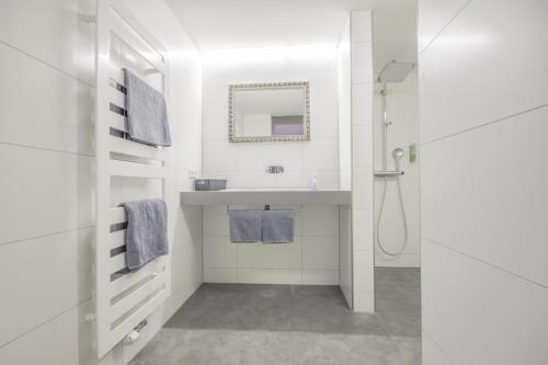 Un baño blanco con lavabo y espejo. en Haus Ella, en Stühlingen