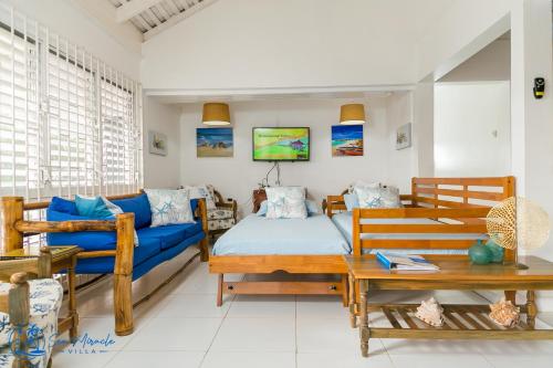 uma sala de estar com um sofá azul e uma mesa em Sea Miracle Villa/Beach Cottage em Silver Sands