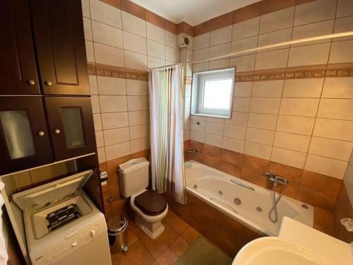 a bathroom with a tub and a toilet and a sink at Terra Comfort Stay in Alexandroupoli
