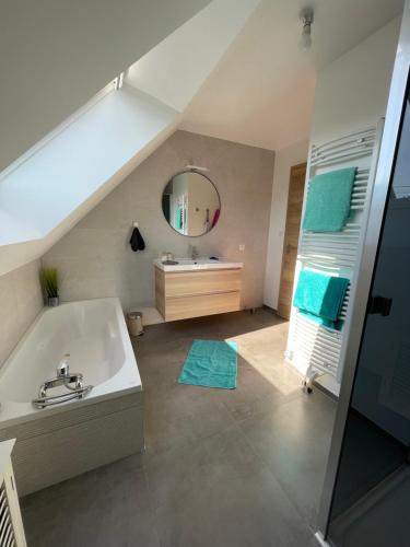 uma casa de banho com uma banheira, um lavatório e um espelho. em Le gîte de l ill proche Strasbourg em Ostwald