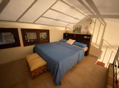 a bedroom with a blue bed and a chair at Villa Rossella in Campu Longu