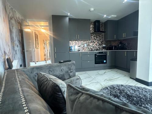 sala de estar con sofá y cocina en Two bed apartment with balcony Slough,Windsor,Legoland, en Slough