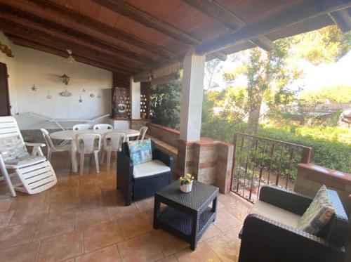 a patio with a table and chairs and a dining room at Villa Rossella in Campu Longu