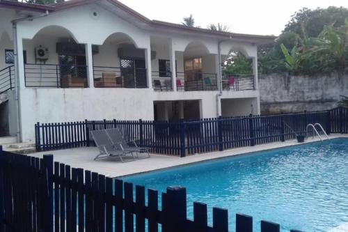 een huis met een zwembad voor een hek bij Villa bleue in Kribi