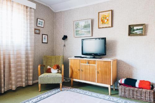 a living room with a tv and a chair at Grandma Tyyne's home in Rovaniemi