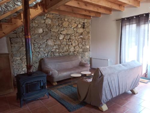 - un salon avec un canapé et un poêle à bois dans l'établissement La pensée sauvage, accueil, partage et ressourcement à la ferme, à Rimont