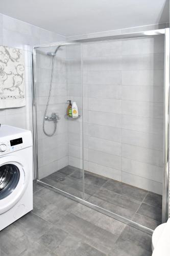 a shower stall in a bathroom with a washing machine at 90° - Ninety Degrees in Nafplio