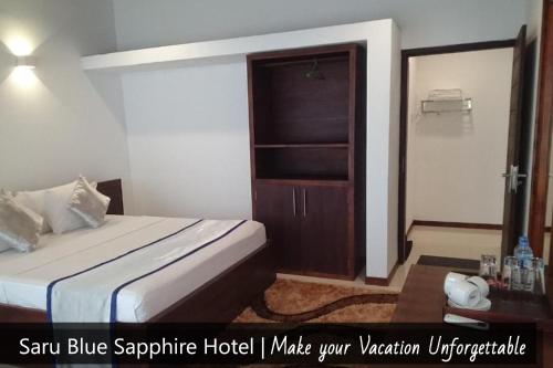 a hotel room with a bed and a closet at Saru Blue Sapphire Hotel in Godakewela