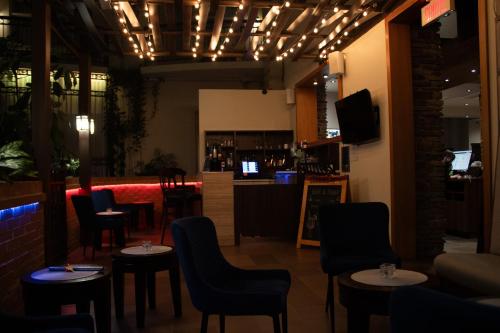 a restaurant with tables and chairs and a bar at Hotel L'Oie des neiges in Lévis