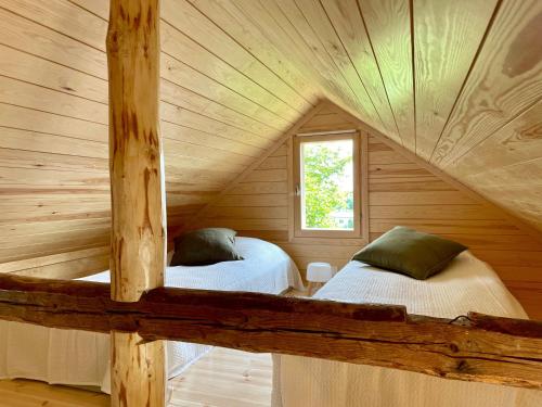 a bedroom with two beds in a log cabin at Torppa, puusauna ja ilmastointi in Lahti