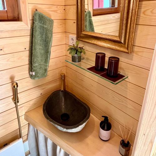 a bathroom with a sink on a wooden wall at Torppa, puusauna ja ulkoporeallas in Lahti
