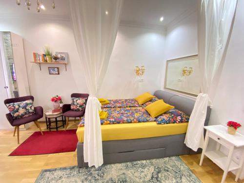 - une chambre avec un lit et deux chaises dans l'établissement Inter Apartment Vienna-Nähe Schönbrunn Palace, à Vienne