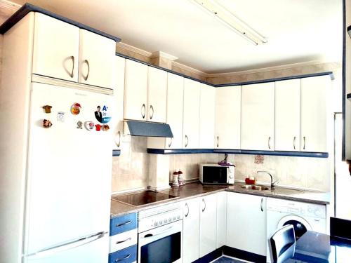 uma cozinha com armários brancos e um frigorífico em Libertad, 1 em Zamora