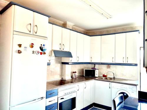 a kitchen with white cabinets and a refrigerator at Libertad, 1 in Zamora