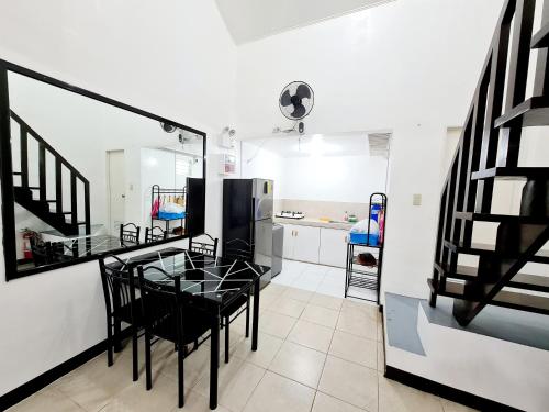 a dining room with a table and chairs and a kitchen at Calapan City Cheapest House Transient Guest Rental L39 in Calapan