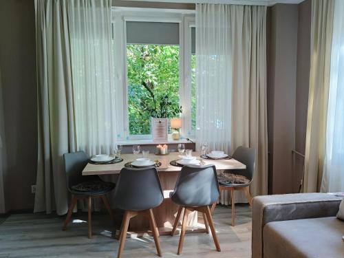 Apartment Rybaki في غدانسك: غرفة طعام مع طاولة وكراسي ونافذة