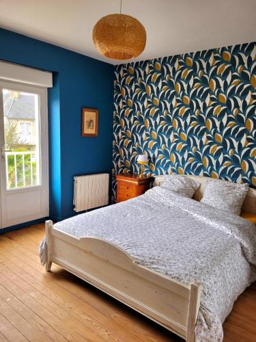 une chambre avec un lit et un mur bleu dans l'établissement Gîte Homard - Bord de mer - 4/6 personnes, à Quinéville