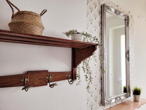 un espejo en un estante con una cesta y plantas en Gîte Homard - Bord de mer - 4/6 personnes, en Quinéville