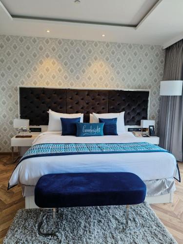 a large bedroom with a large bed with blue pillows at Amanora The Fern Hotels & Club in Pune
