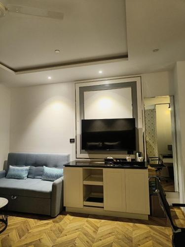 a living room with a couch and a flat screen tv at Amanora The Fern Hotels & Club in Pune