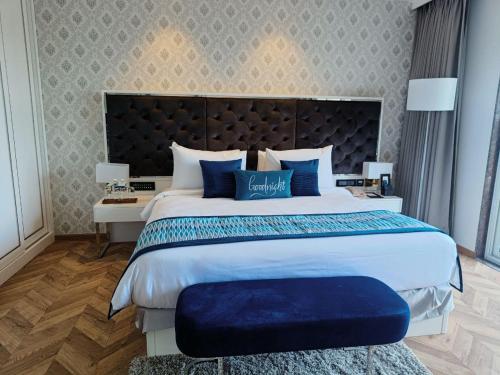 a bedroom with a large bed with blue pillows at Amanora The Fern Hotels & Club in Pune