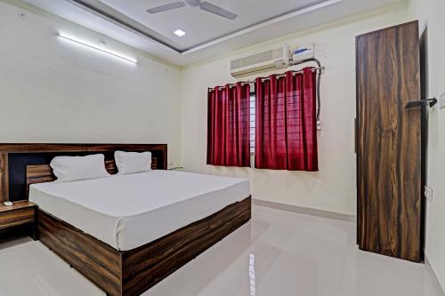 sypialnia z łóżkiem i czerwoną zasłoną w obiekcie Hotel Midway Treat Dhar w mieście Dhār