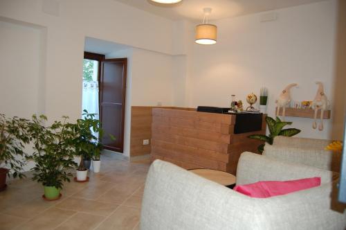 a living room with two couches and potted plants at MIRANDOLINA Bed and Breakfast in Rocca di Cambio