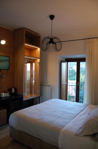 a bedroom with a large white bed and a window at MIRANDOLINA Bed and Breakfast in Rocca di Cambio
