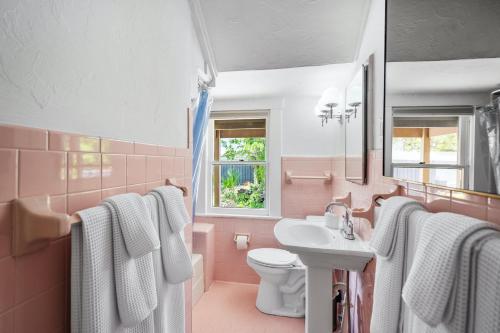 een roze badkamer met een wastafel en een toilet bij Julia Place in Sarasota