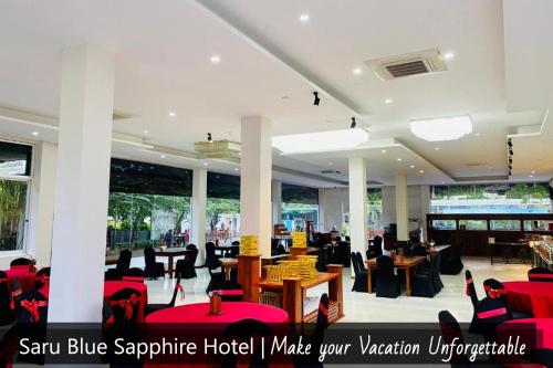 a restaurant with red chairs and tables in a building at Saru Blue Sapphire Hotel in Godakewela