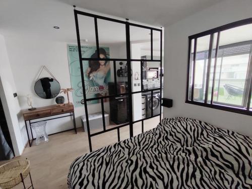 uma cama com estampa de zebra num quarto com uma janela em Luxe naturist 3 étoiles vue mer D46 em Cap d'Agde