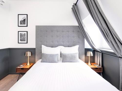 une chambre avec un grand lit blanc avec deux lampes dans l'établissement LivinParis - Luxury AC 2 & 3 Bedrooms Le Louvre, à Paris