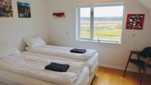 2 camas individuales en una habitación con ventana en Mengi Countryside, en Kjarnholt