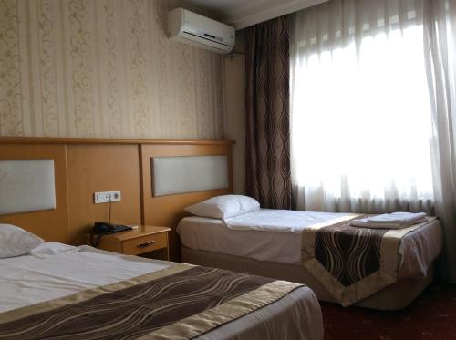 a hotel room with two beds and a window at Ilıcak Hotel in Istanbul