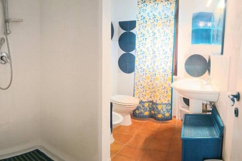 un baño con inodoro y lavabo en l'ibiscus, en Brucoli