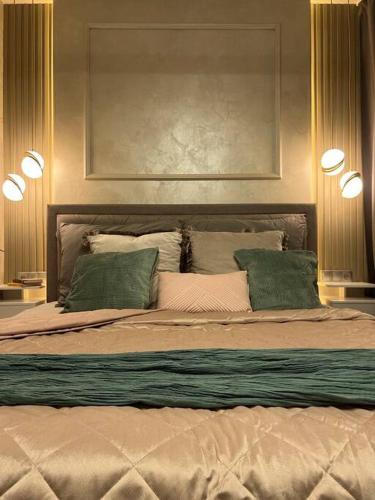 een slaapkamer met een groot bed met 2 groene kussens bij Luxury Pearl with Parking place in Holešovice in Praag