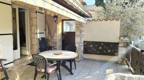 a patio with a table and chairs on a patio at Les Lauriers Roses in Salavas