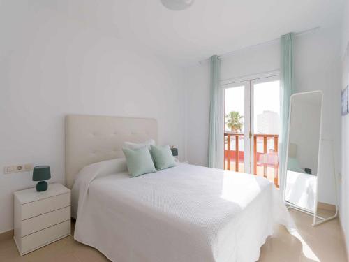 a white bedroom with a white bed and a window at Mahostly Sun and Spa in Puerto del Rosario