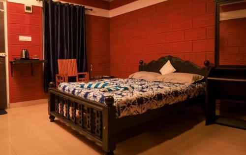 a bedroom with a bed and a red wall at Mountain Manor in Vayittiri