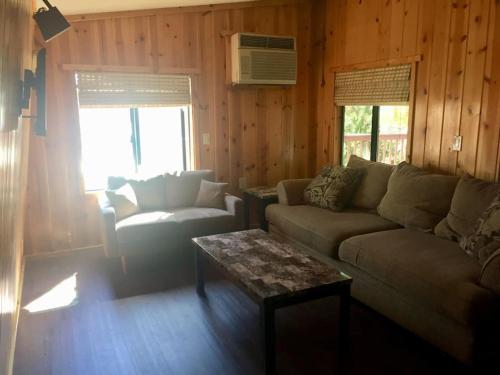 a living room with a couch and a coffee table at Tillie Creek Retreat: a Creekside Oasis in Wofford Heights